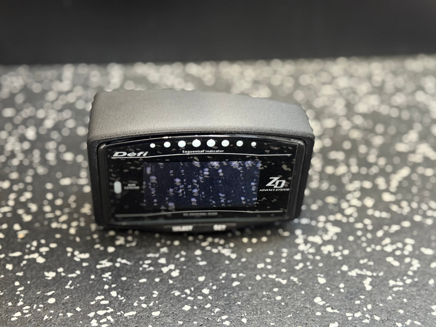 Defi ZD device on a speckled gray surface