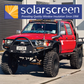 Red pickup truck with 'solarscreen' logo and text on a building.